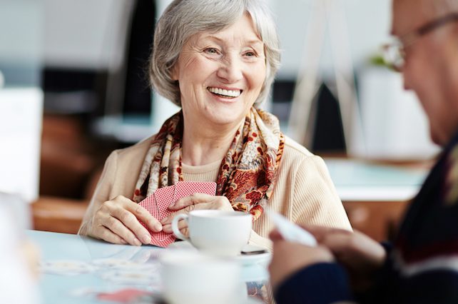 Older woman drinking a cup of tea and smiling